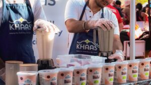 Retail experiential marketing activation featuring live product sampling, with brand ambassadors preparing and demonstrating dairy products at a branded booth.