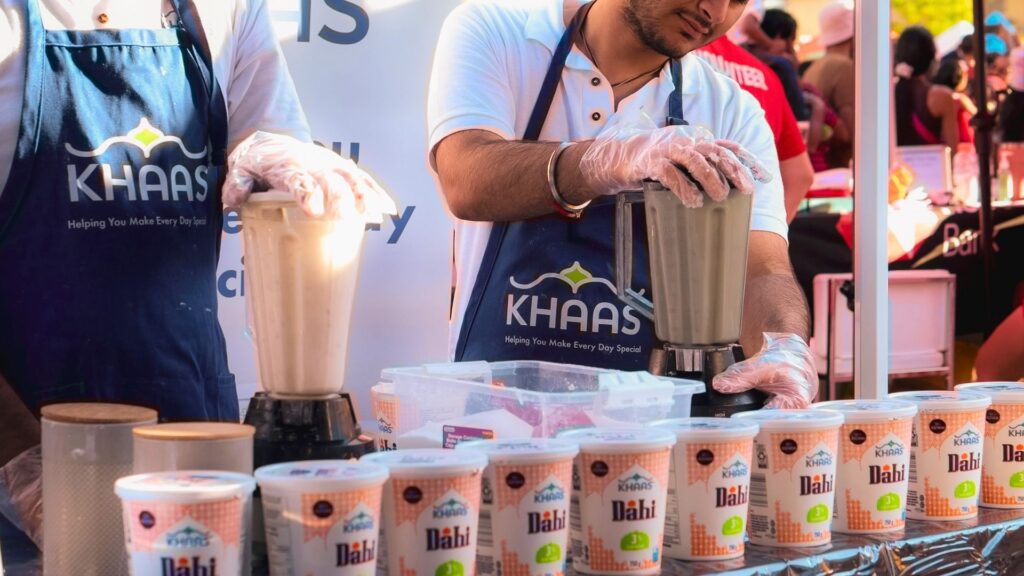 Experiential marketing product sampling with brand ambassadors preparing food and engaging customers at a live brand activation