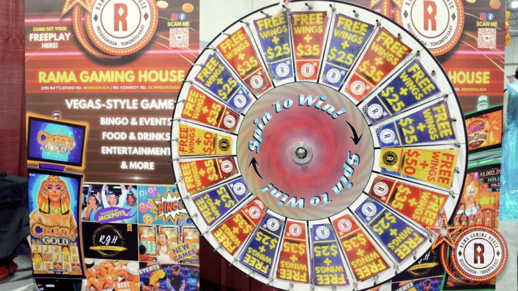 Interactive prize wheel brand activation at Rama Gaming House booth offering free wings and cash rewards.