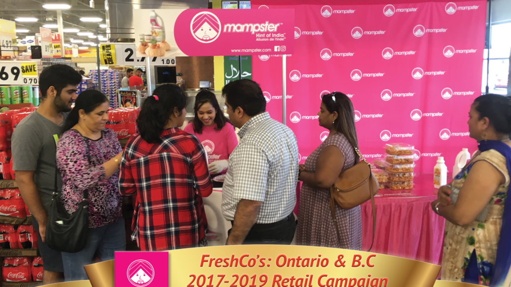 In-store product sampling activation with brand ambassador engaging shoppers at Mampster booth in FreshCo grocery store