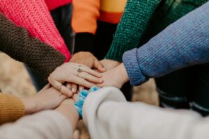 Close-up of diverse hands stacked together, representing teamwork, collaboration, and community.
